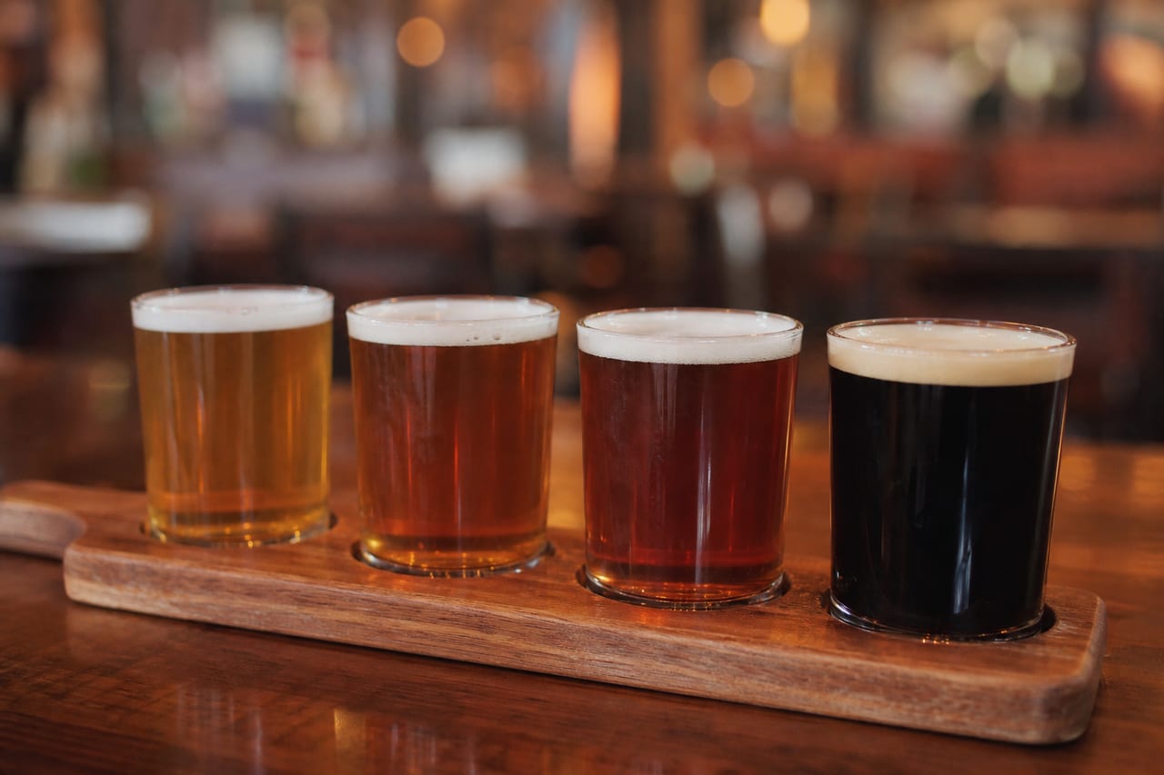 Four beers on a wooden tasting paddle